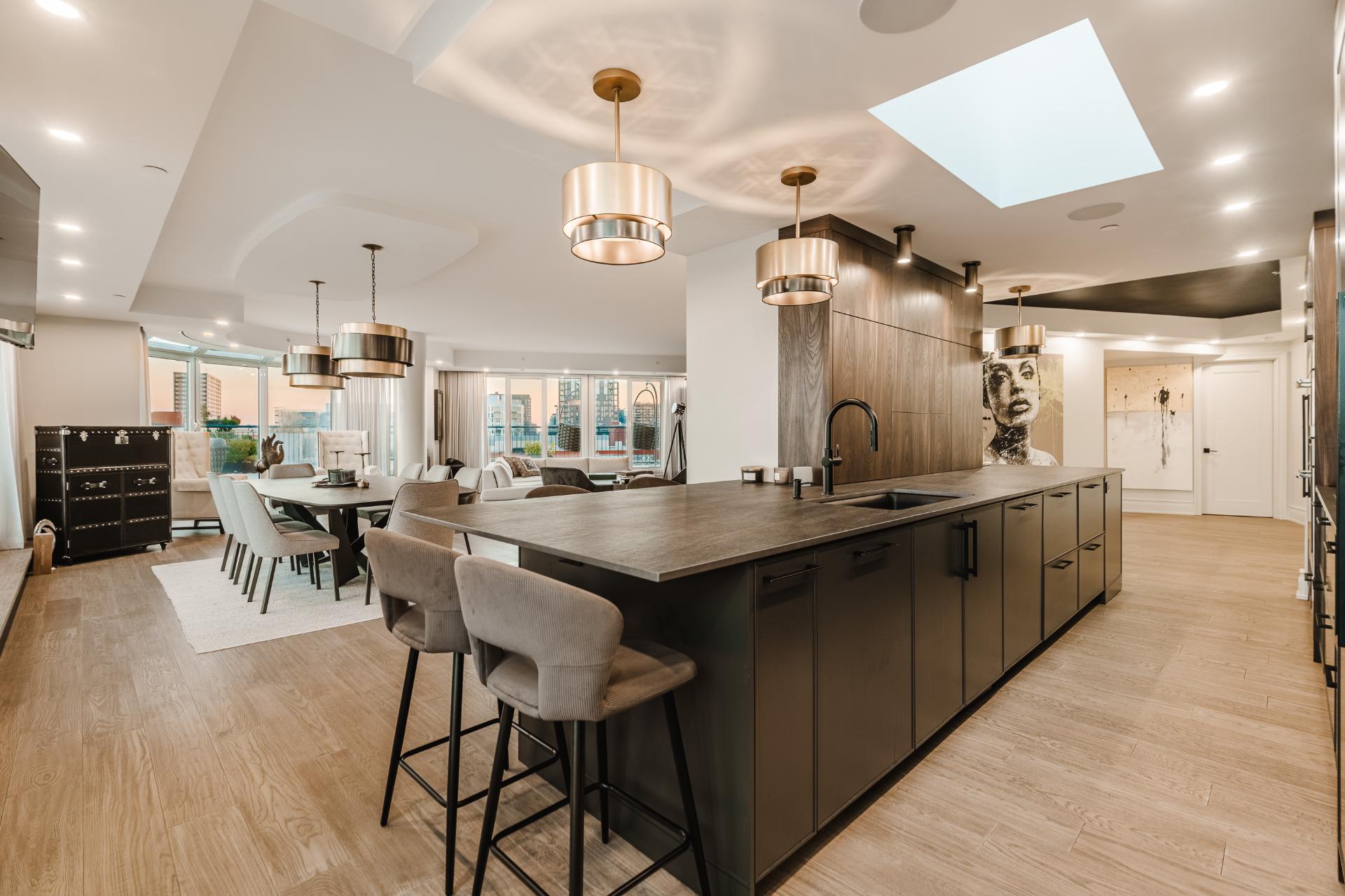 Cuisine sur mesure avec immense îlot, électroménagers intégrés et rangements pleine hauteur