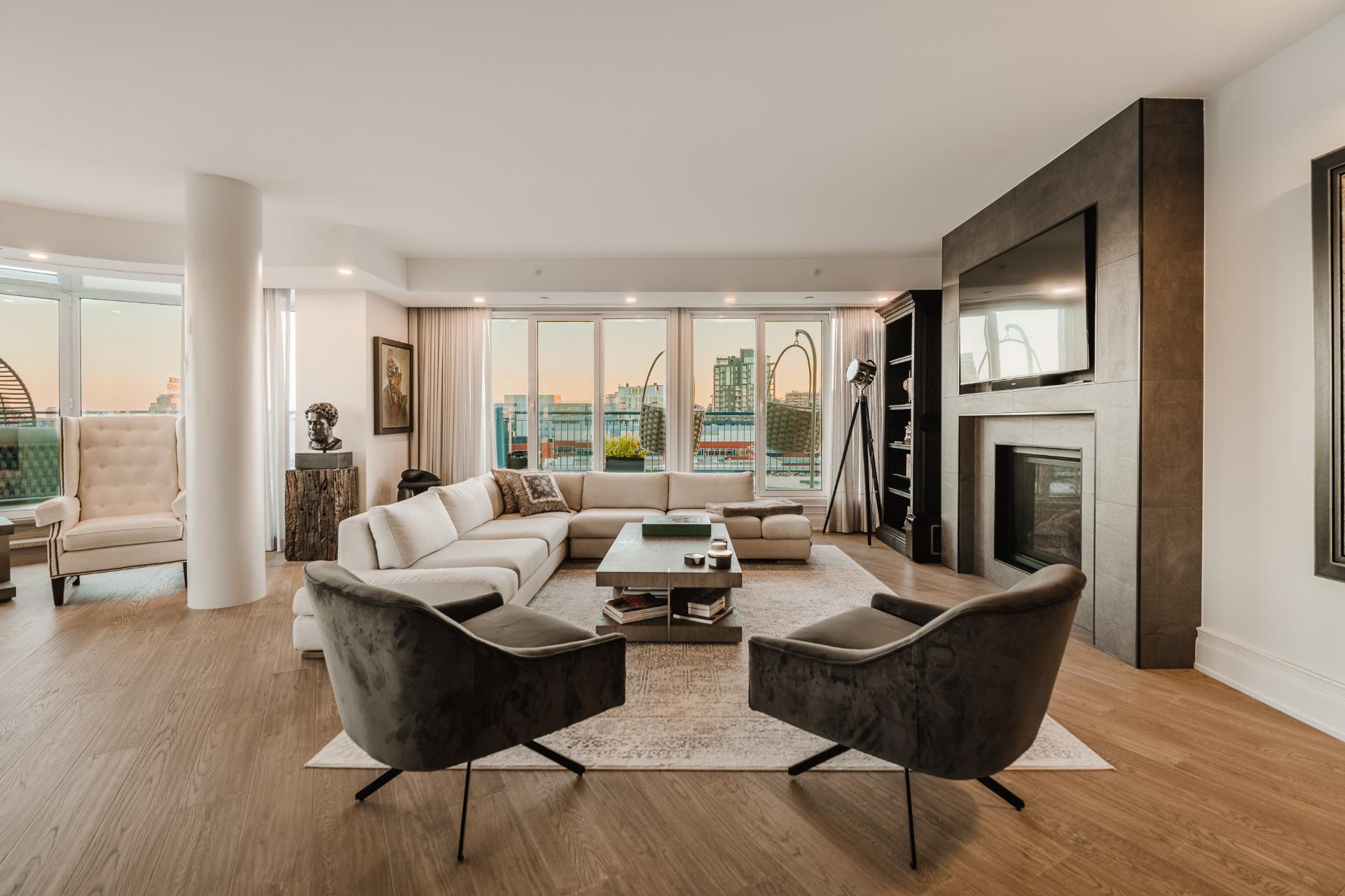 Salon contemporain avec foyer, ouvert sur la salle à manger et la fenestration panoramique